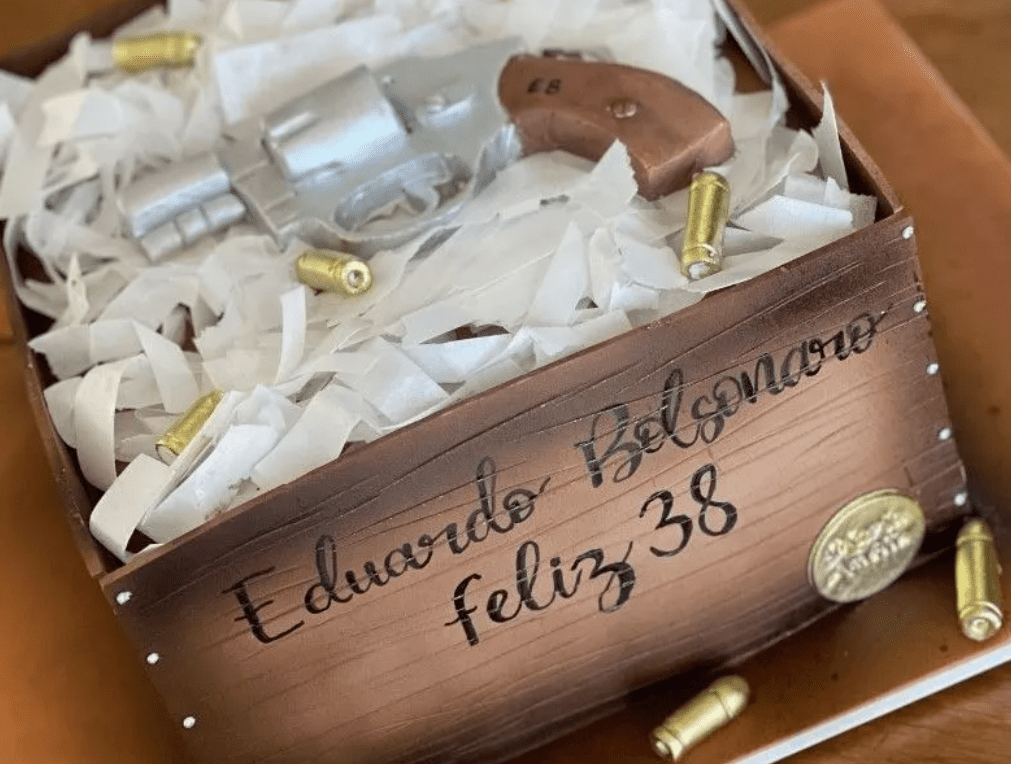 Eduardo Bolsonaro comemora 38 anos com bolo decorado com revólver O deputado federal e filho do presidente também participou de ato a favor de armas no dia de seu aniversário
